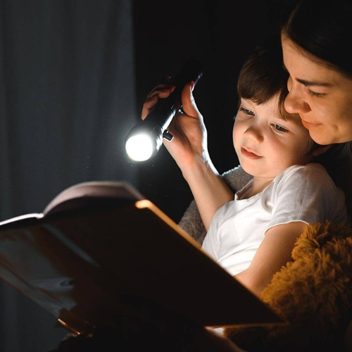 mum and kid reading book with VitalTac Flashlight